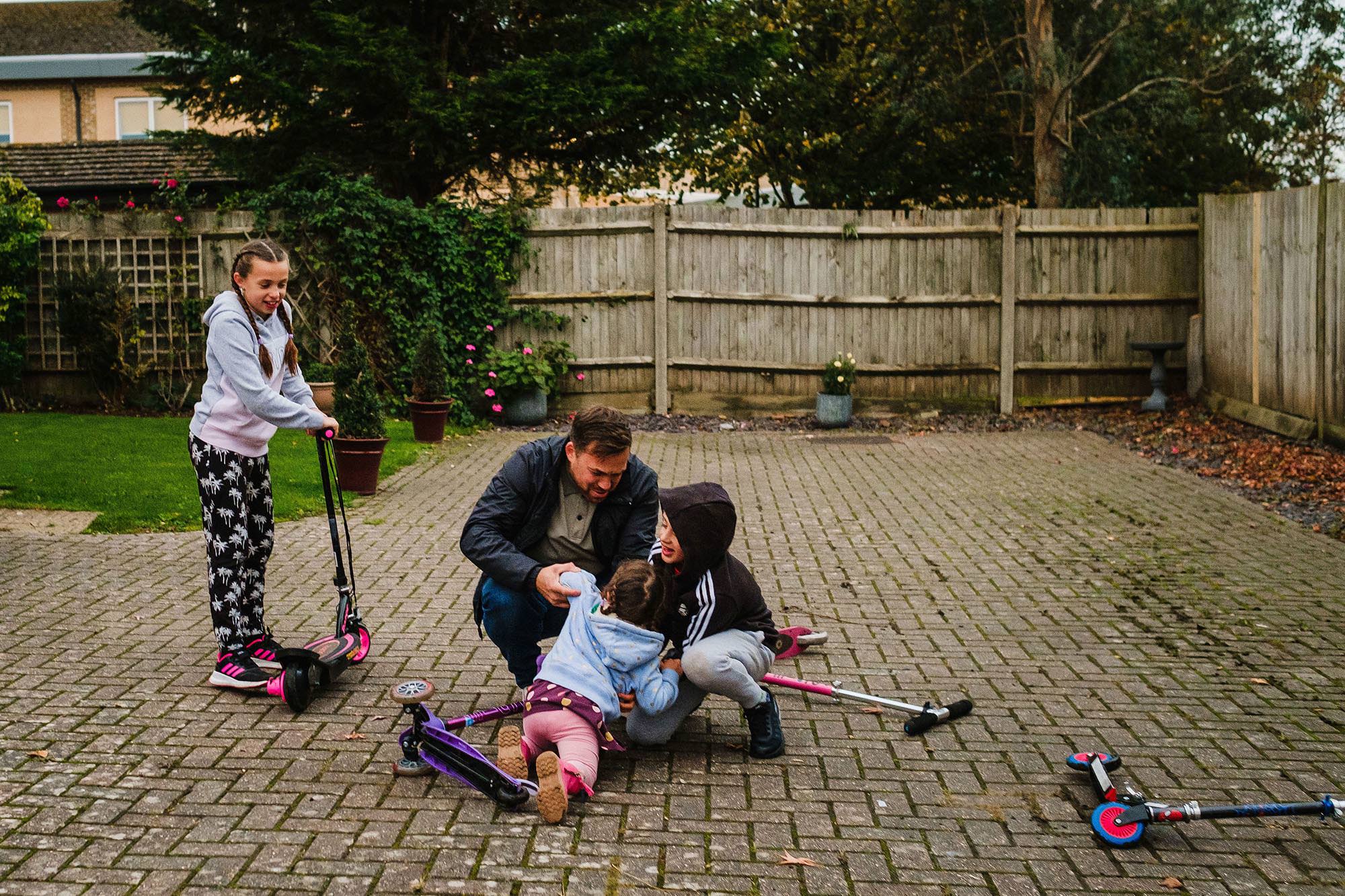 siblings and dad comforting daughter