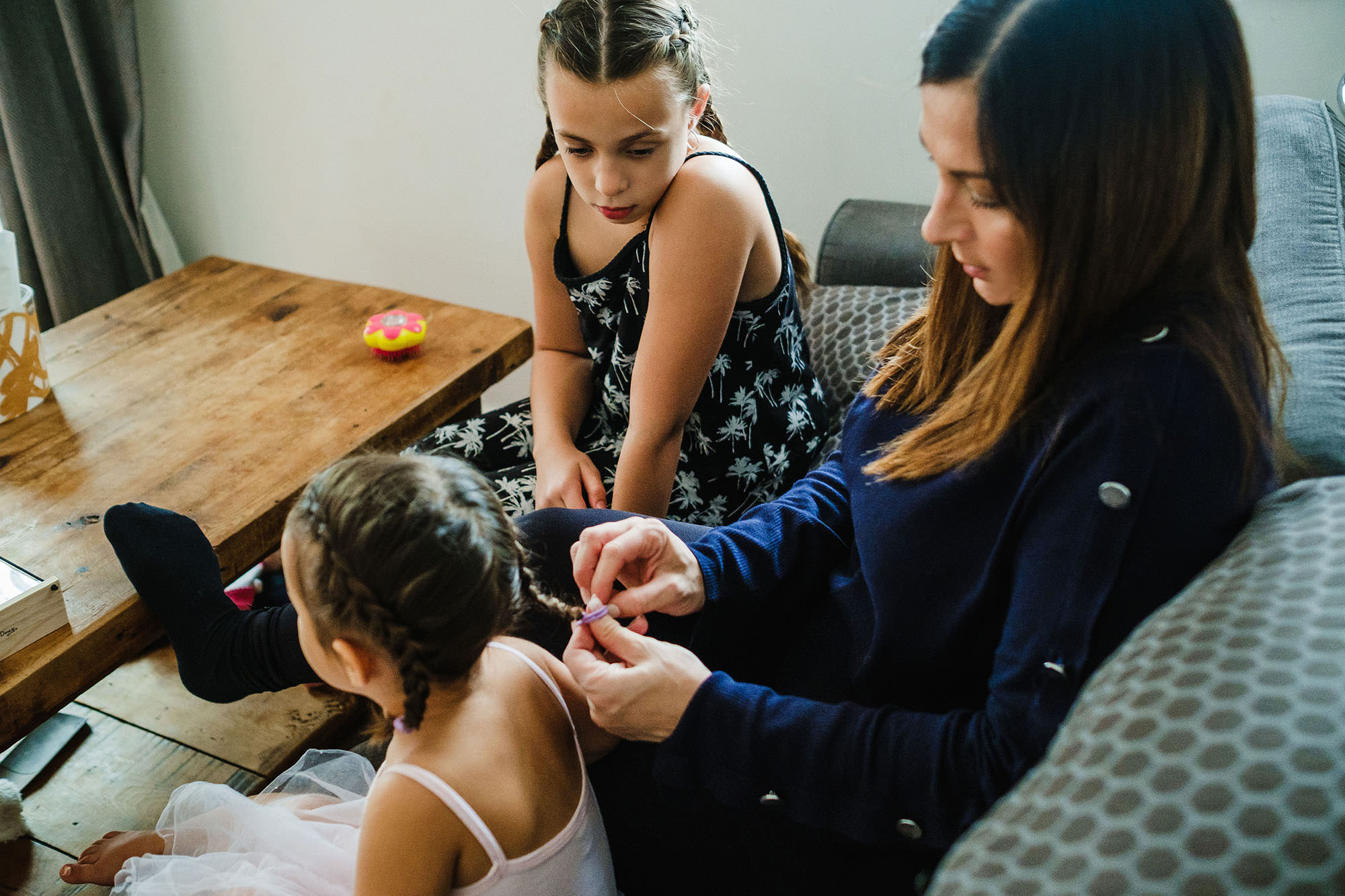 mum braiding daughters hair